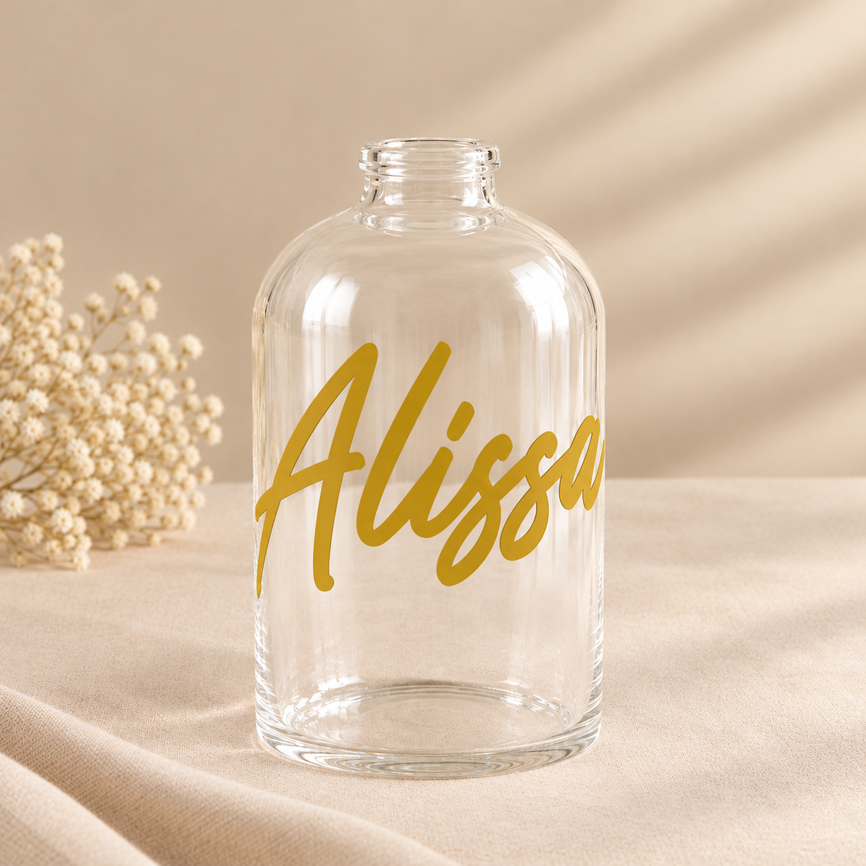 Gouden Alissa-fles in zacht beige licht